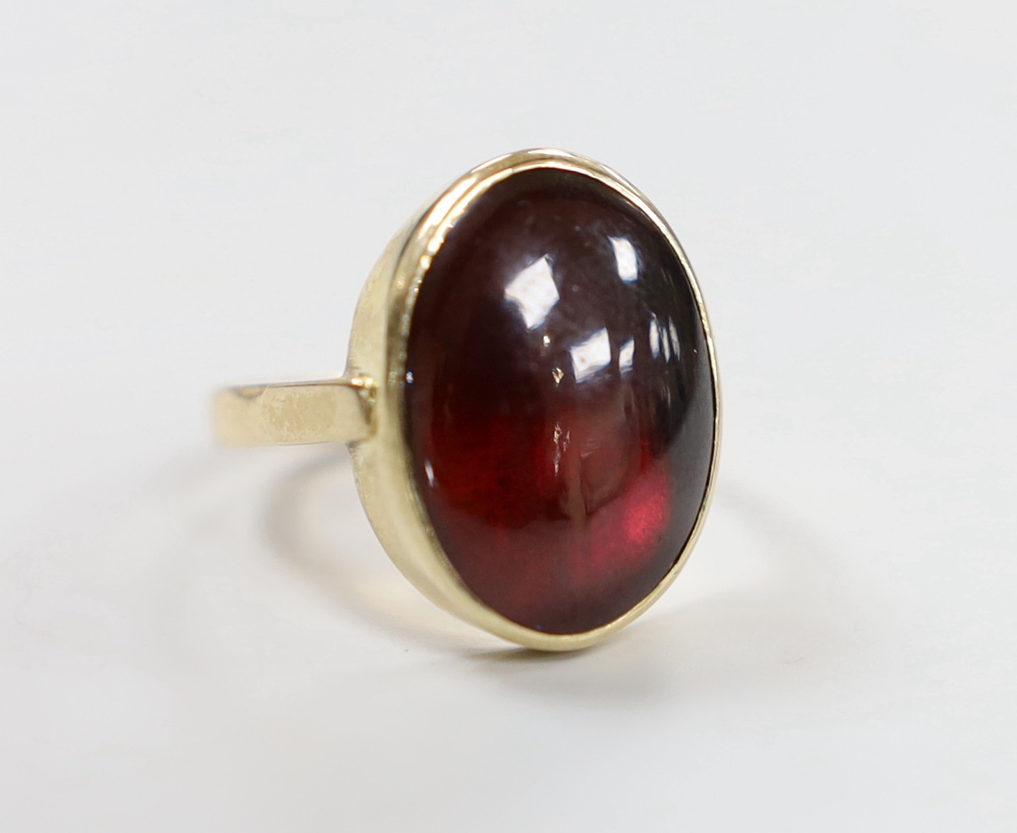 A 9ct and foil backed? oval cabochon garnet set ring, size O, gross weight 5.2 grams.